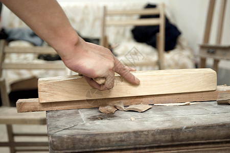木头工艺品匠人使用刨刀进行木材处理背景
