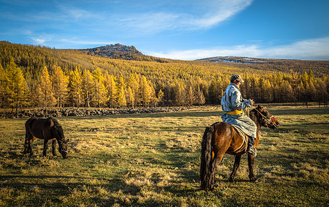 秋天草原上骑马的蒙古汉子图片