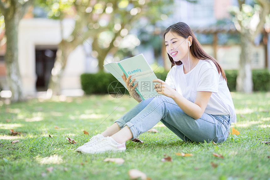 坐在校园草坪上看书的女学生图片