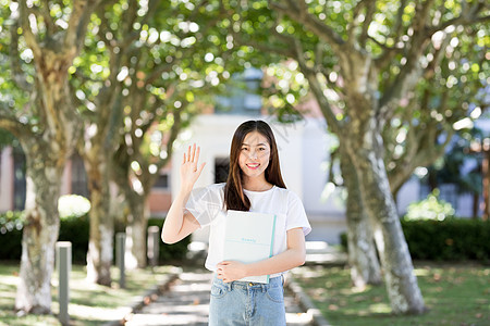 校园里拿着书微笑打招呼的女生背景图片