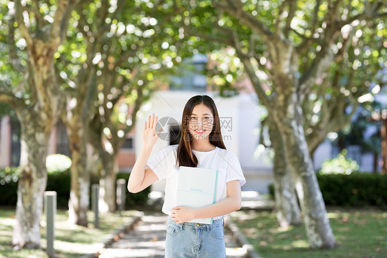 校园里拿着书微笑打招呼的女生图片