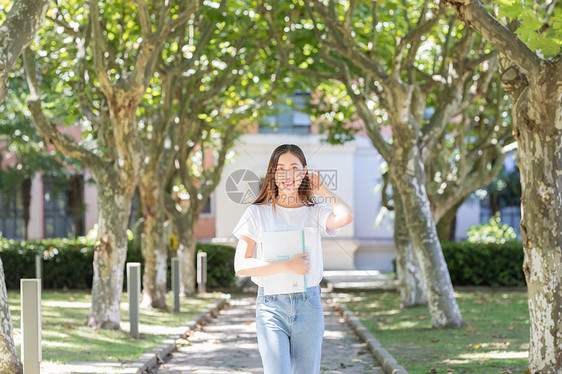 学校里抱着书边走路边撩头发的女同学图片