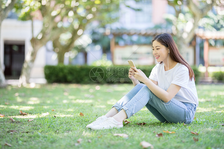 坐在校园草坪上玩手机的女生图片