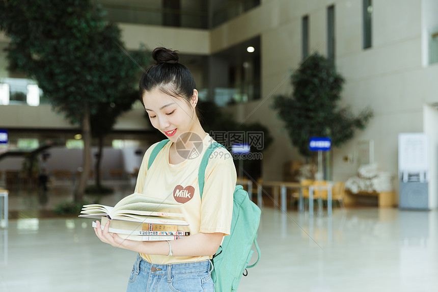 教学楼里抱着书本的女生图片