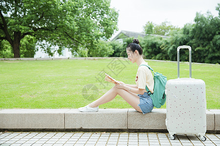 校园草地前女生在看书高清图片