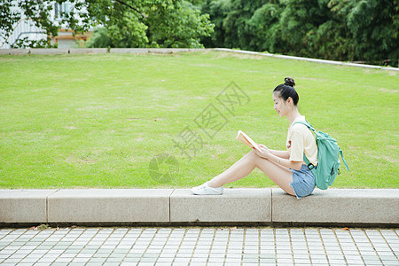 女孩在草坪读书校园草地前女生在看书背景