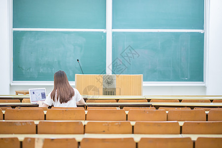 空旷的教室里正在学习的女生背影图片