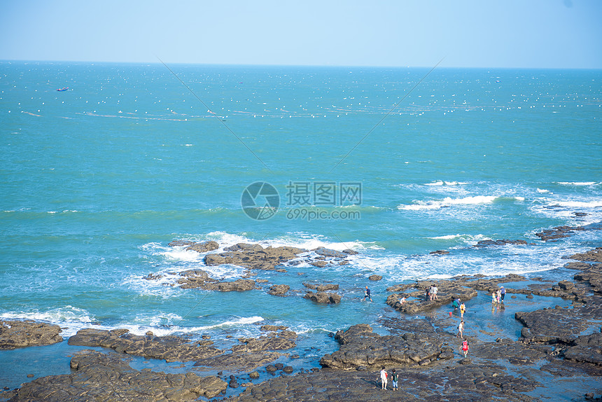 蓝色海岸线海滩边的礁石图片