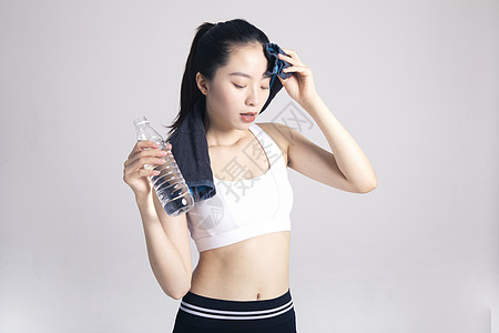擦汗喝水的运动女性棚拍图片