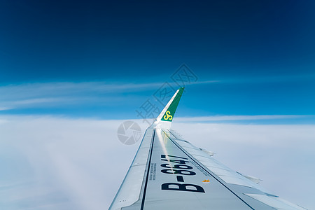 旅途中的彩虹旅途中舷窗外蓝天中的机翼背景