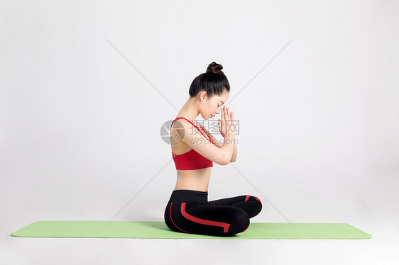 年轻女性做双手合十的瑜伽动作图片