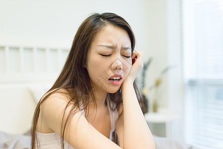 女性蛀牙牙痛蛀牙牙痛坐在床上的女生背景