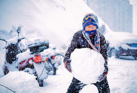 窗外大雪雪中堆雪球玩雪的男孩背景