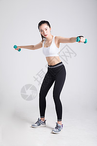 年轻女性健身哑铃侧平举动作高清图片
