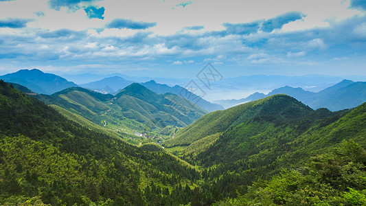 森林度假蓝天白云下的绿色山脉背景