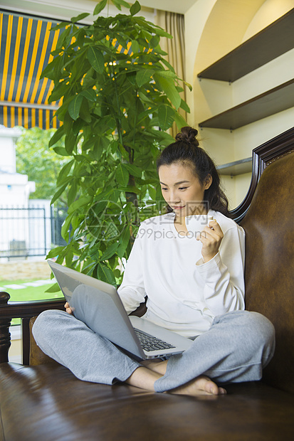 年轻女性在沙发上看电脑图片