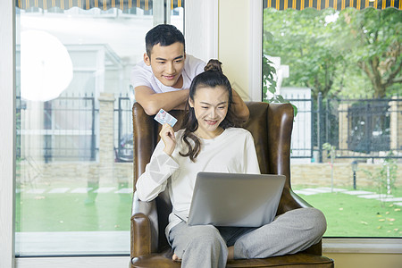 年轻夫妇在客厅用电脑网购图片