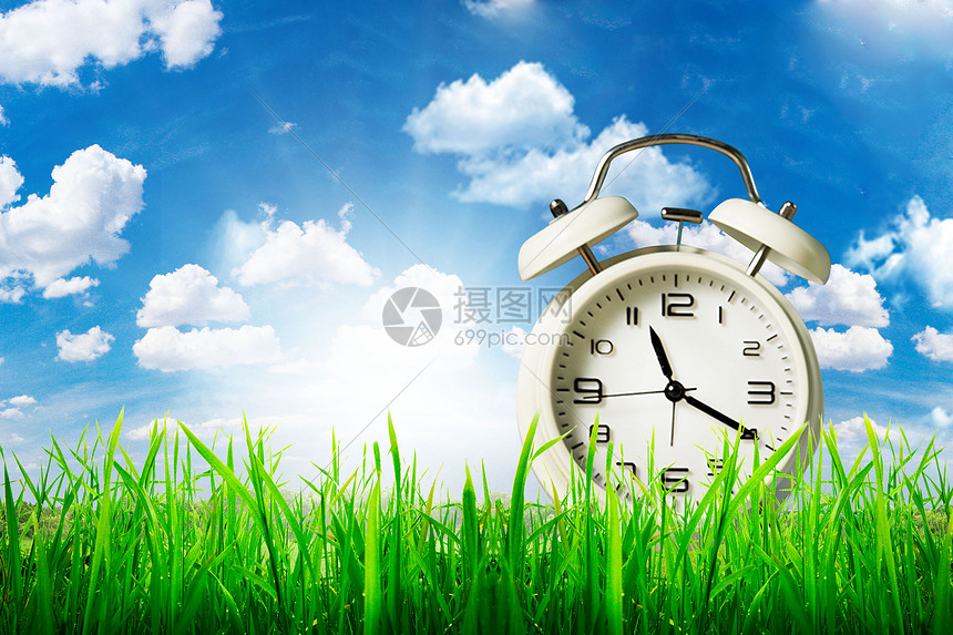 绿草地上的时钟背景图片
