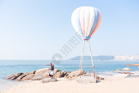 夏装女模特海边热气球旁聆听大海声音的女模特背景