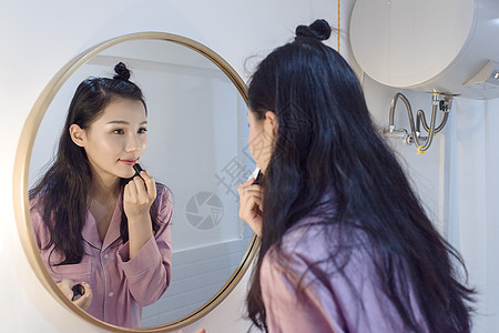女子化妆镜前涂口红背景图片