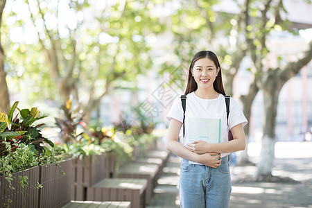 校园里背着书包拿着书的同学背景图片