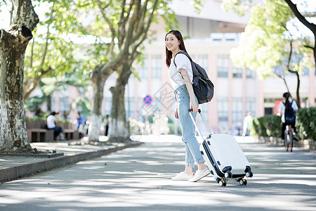 校园里拖着行李箱的女生高清图片