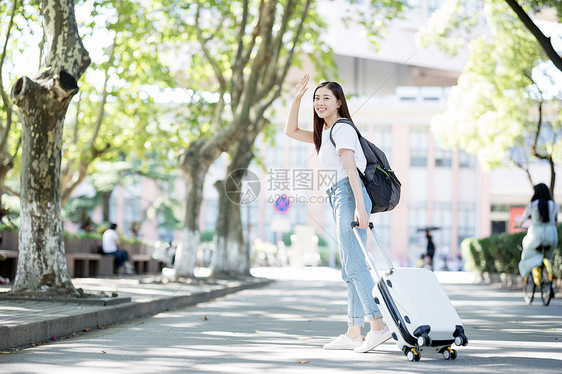 校园里拖着行李箱的女生