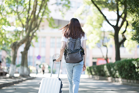 同学旅行拉着行李箱的女生背影背景