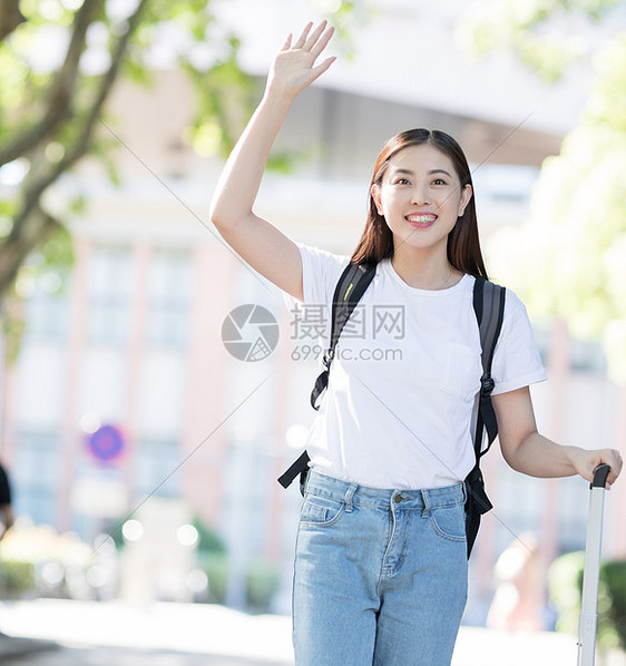 拉着行李箱微笑招手的女生