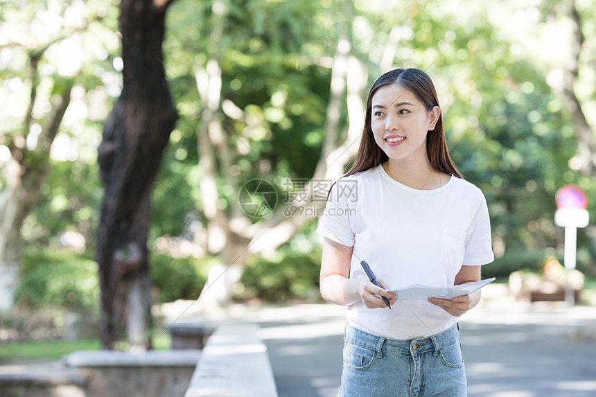 抱着书拿着笔的女同学图片