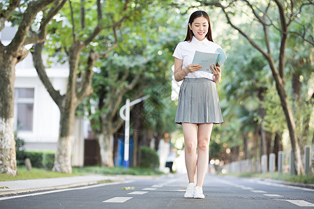 拿着课本准备去上课的大学生图片