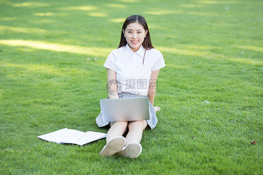 绿色草坪上休闲学习的女生图片