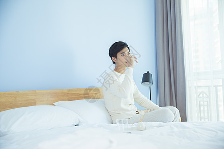 卧室床边喝水的年轻男性图片