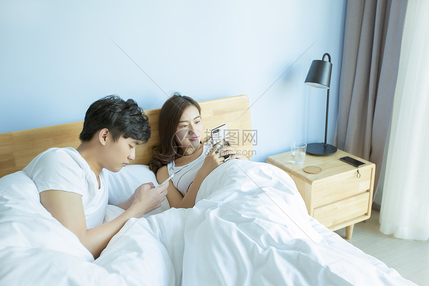 年轻情侣在床上打闹图片