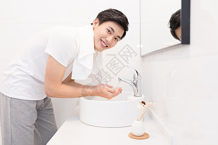浴室洗漱正在洗脸的年轻男士背景