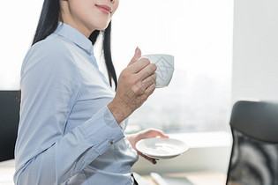 在办公室喝咖啡的自信职业女性图片