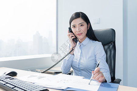 办公室里微笑打电话的职场女性背景图片