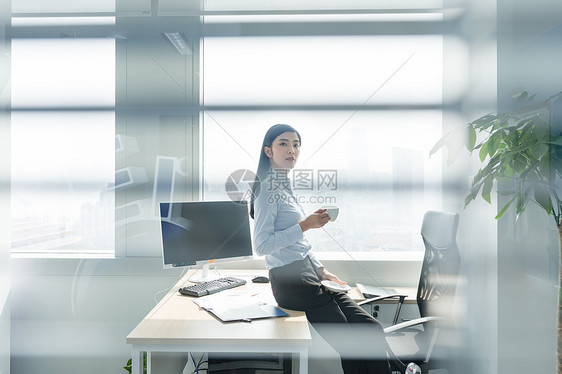在办公室喝咖啡的自信职业女性