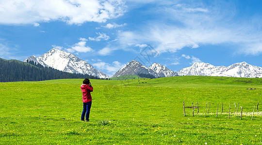 雪山草地拍摄雪山的女摄影师背景