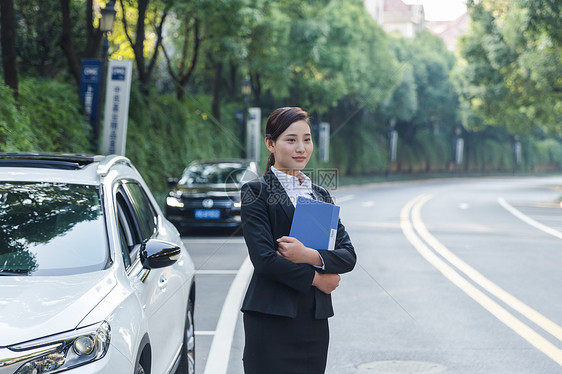 车旁手拿文件夹的商务女士图片