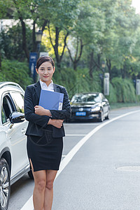 车旁手拿文件夹的商务女士图片