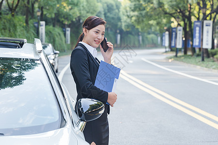 商务女士在车旁打电话图片