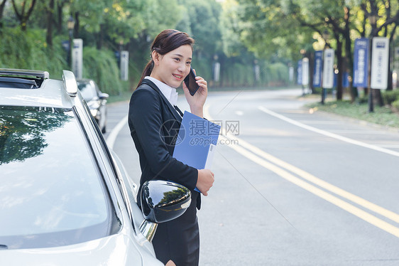 商务女士在车旁打电话图片