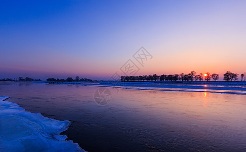 结冰的湖面冬天寒冷的吉林雾凇岛湖面日落背景