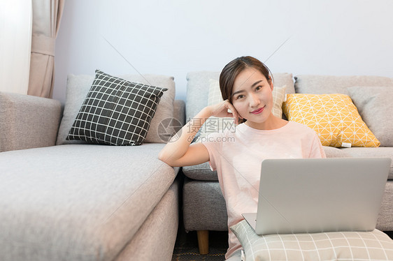 年轻美女靠着沙发玩电脑图片