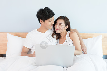 躺在床上看电脑的年轻情侣图片