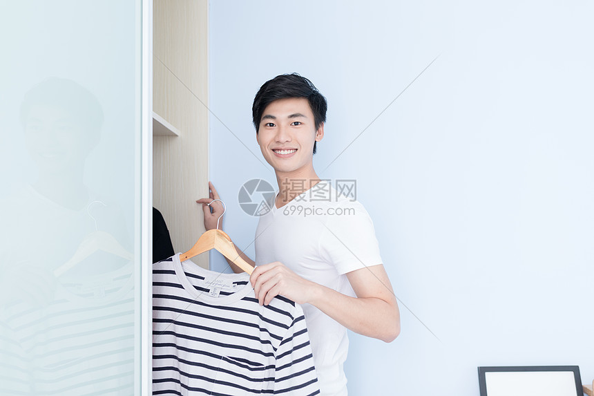 帅气男子打开衣柜拿衣服