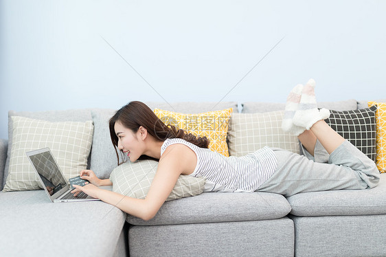 躺在沙发上网购的女性