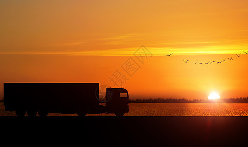 夕阳下交通运输货车剪影背景图片