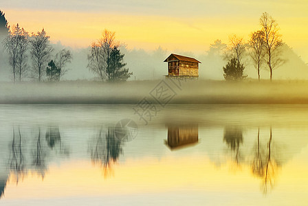 清晨乡村充满雾气的湖边倒影高清图片